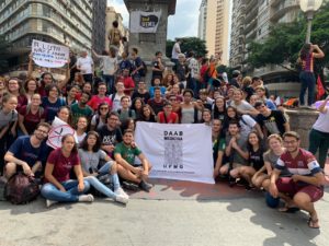 Foto de dezena de estudantes com a bandeira do DAAB na praça Sete em Belo Horizonte