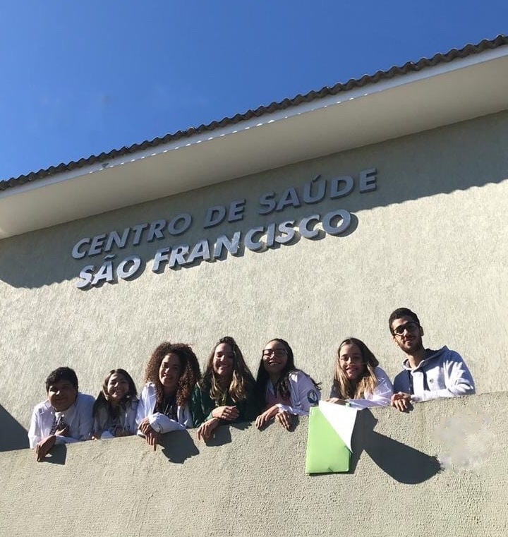 Alunos e alunas da Medicina sorriem na fachada do Centro de Saúde São Francisco