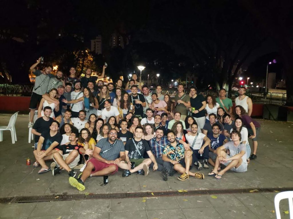 Foto do churrasco da gestão de 2019 com ex membros do DAAB, na foto dezenas de pessoas estão abraçadas na parte externa da sede do DAAB