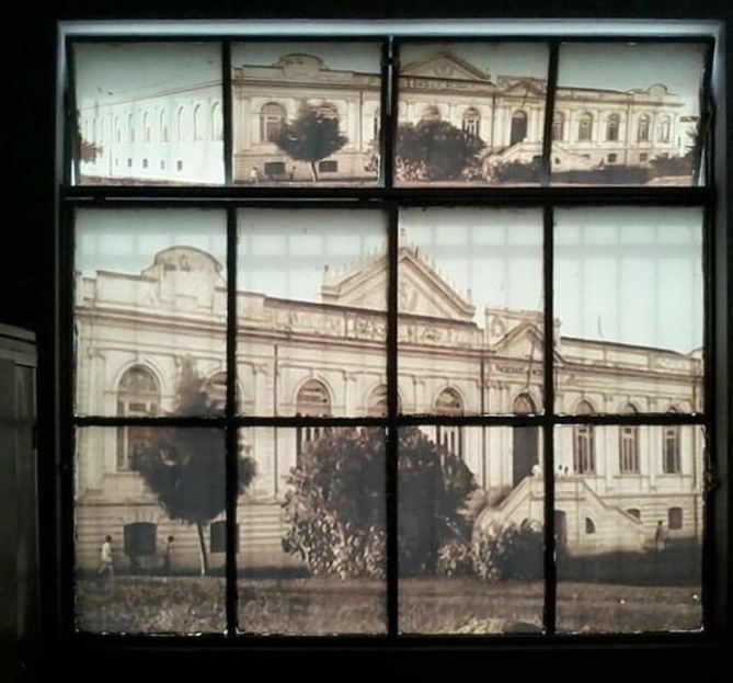 Foto de uma das janelas do DAAB, nela está plotado o antigo prédio do hospital São Geraldo